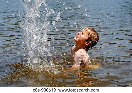 Stock photo of a 9 year old boy splashing around with a ball in the water View Large Photo Image Stock Photo - Stock photo of a 9 year old boy splashing around with a ball in the water. Fotosearch