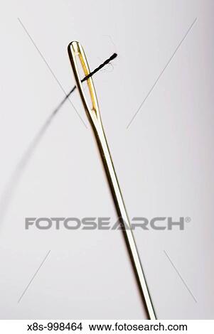 Stock photo of a black piece of thread threaded through the eye of a sewing needle View Large Photo Image Picture - Stock photo of a black piece of thread threaded through the eye of a sewing needle. Fotosearch