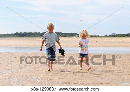 Stock Photo - Stock photo of a boy and girl walking on the beach. Fotosearch