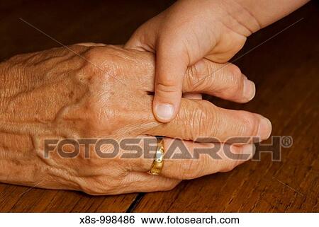 Stock photo of a child holding her grandmas hand View Large Photo Image Stock Photograph - Stock photo of a child holding her grandmas hand. Fotosearch