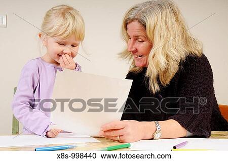 Stock Image - Stock photo of a four year old girl and her mother sitting at a table drawing pictures. Fotosearch
