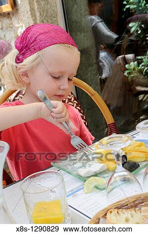 Stock photo of a four year old girl enjoying a plate of fish and chips at a restaurant View Large Photo Image Stock Photo - Stock photo of a four year old girl enjoying a plate of fish and chips at a restaurant. Fotosearch
