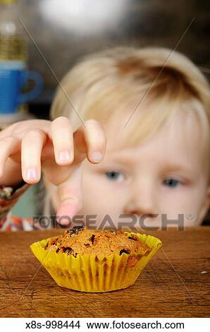 Stock photo of a little girl looking longingly at a cake on the kitchen table View Large Photo Image Picture - Stock photo of a little girl looking longingly at a cake on the kitchen table. Fotosearch