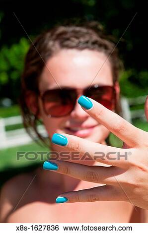 Stock Photograph - Stock photo of a teenage girl showing of her painted finger nails. Fotosearch