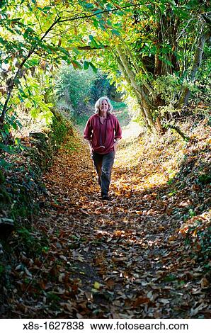 Stock photo of a woman walking down a country path View Large Photo Image Stock Photo - Stock photo of a woman walking down a country path. Fotosearch