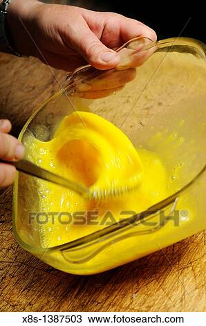 Stock Image - Stock photo of a woman whisking free range eggs. Fotosearch