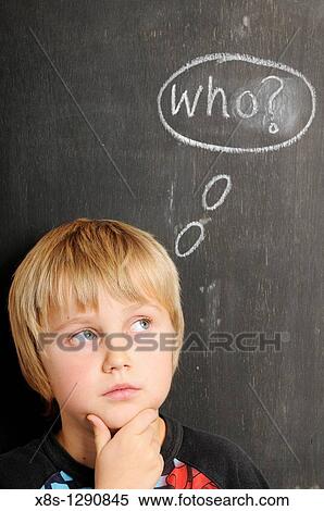 Stock Photography - Stock photo of a young boy in fornt of a blackboard with chalk thought bubbles spelling the word WHO. Fotosearch