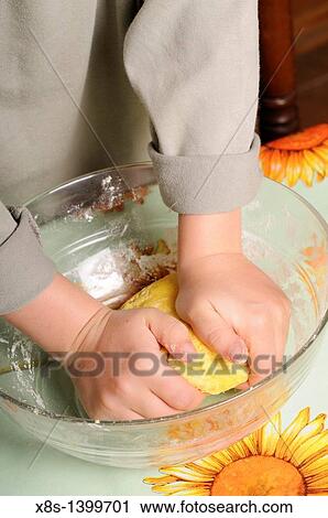 Stock Image - Stock photo of a young boy kneading fresh pasta dough in a bowl. Fotosearch