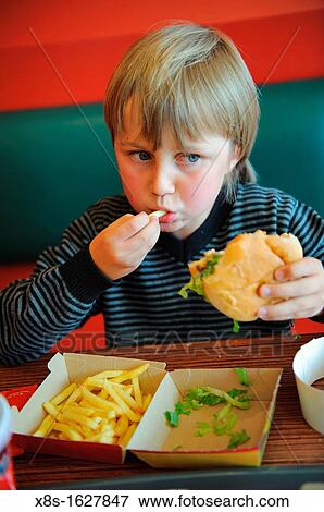 Stock photo of an 11 year old boy eating fast food in a restaurant View Large Photo Image Stock Photo - Stock photo of an 11 year old boy eating fast food in a restaurant. Fotosearch