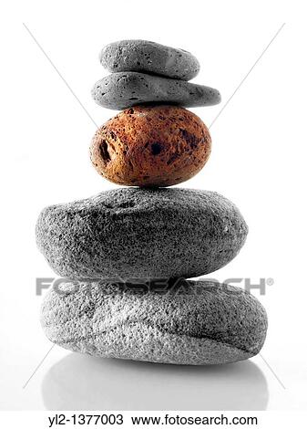 Stock Image - Stones stacked ontop of each other Black and white with one coloured stone. Fotosearch