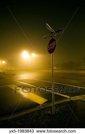 Stop sign at crossroads lit by street lights at night. View Large Photo Image Stock Image - Stop sign at crossroads lit by street lights at night.. Fotosearch