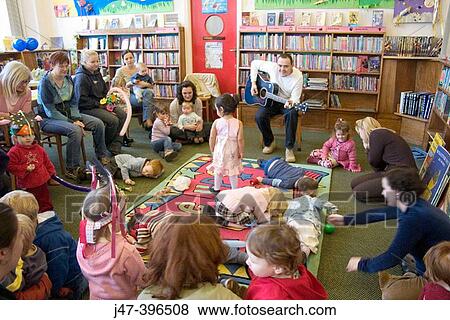Storytime at the library, children listening to man playing the guitar View Large Photo Image Stock Photo - Storytime at the library, children listening to man playing the guitar. Fotosearch