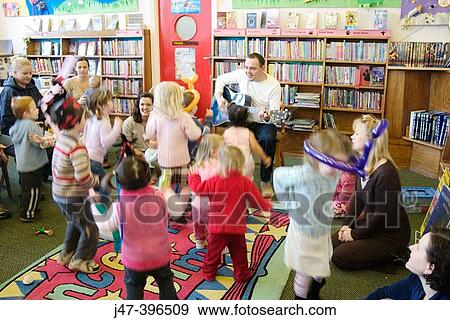 Storytime at the library, children dancing to man playing the guitar View Large Photo Image Stock Photo - Storytime at the library, children dancing to man playing the guitar. Fotosearch