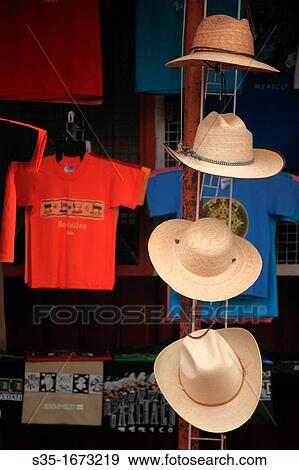 Stock Photo - Straw hats and T-shirts for sale in the souvenir market in Xochimilco Xochimilco Mexico.. Fotosearch