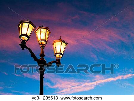 Stock Image - Street lamps in the early morning. Port of Castro Urdiales, Cantabria, Spain.. Fotosearch