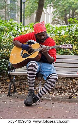 Street Musician tuning his guitar in a park in Savannah GA View Large Photo Image Stock Photography - Street Musician tuning his guitar in a park in Savannah GA. Fotosearch