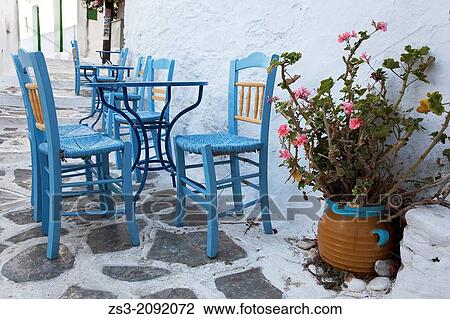 Stock Image - Street scene with blue tables and chairs, Chora, Amorgos, Cyclades Islands, Greek Islands, Greece, Europe.. Fotosearch