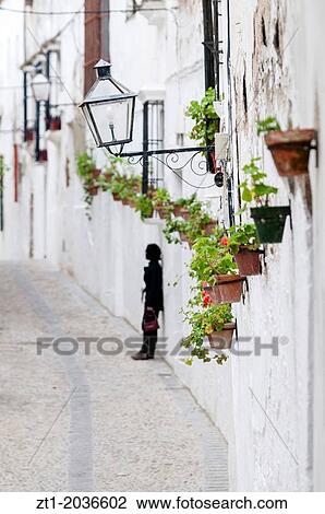 Stock Image - Street with geraniums in Arcos De La Frontera.. Fotosearch