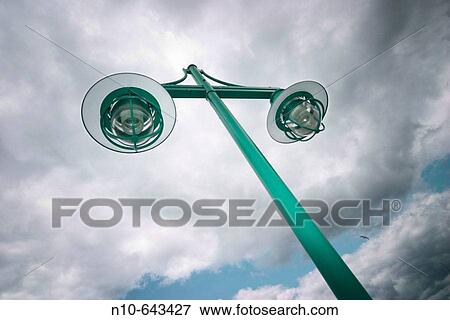 Streetlights beneath a cloudy sky. View Large Photo Image Stock Photo - Streetlights beneath a cloudy sky.. Fotosearch