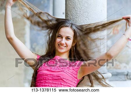 Stretching her hair sideways happy young woman View Large Photo Image Stock Photography - Stretching her hair sideways happy young woman. Fotosearch