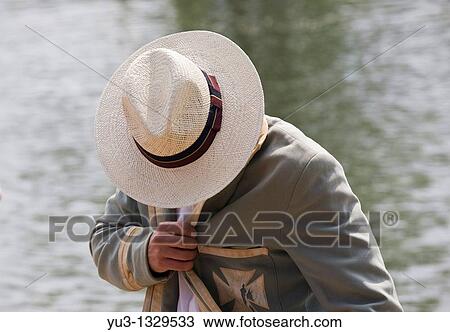 Stock Image - Student spectator in panama hat and old college blazer during Oxford University Eights Week rowing competition, Oxford, England, UK. Fotosearch