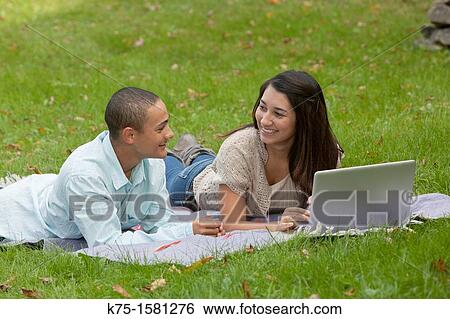 Students lying on blanket studying with laptop View Large Photo Image Stock Photograph - Students lying on blanket studying with laptop. Fotosearch