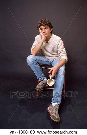 studio image of bored teenage boy sitting in chair View Large Photo Image Stock Image - studio image of bored teenage boy sitting in chair. Fotosearch