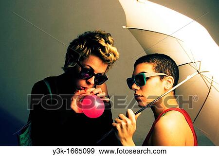 Studio picture of two girls playing with a ballon and an umbrella. View Large Photo Image Stock Photo - Studio picture of two girls playing with a ballon and an umbrella.. Fotosearch