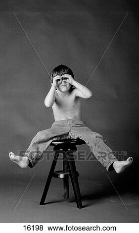 Studio portrait of boy on stool making pretend eyeglasses with his hands View Large Photo Image Stock Photo - Studio portrait of boy on stool making pretend eyeglasses with his hands. Fotosearch