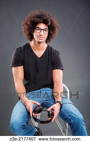 Stock Photo - studio portrait of young man in front of gray background.. Fotosearch