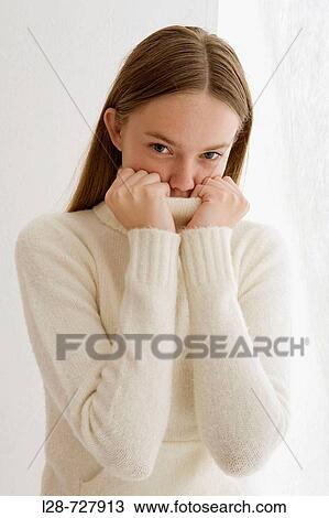 Studio portrait of young woman covering face with turtleneck collar View Large Photo Image Stock Image - Studio portrait of young woman covering face with turtleneck collar. Fotosearch
