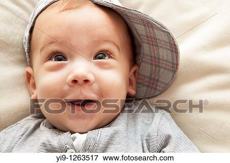 Studio shot of baby boy wearing hat and smiling View Large Photo Image Stock Photo - Studio shot of baby boy wearing hat and smiling. Fotosearch