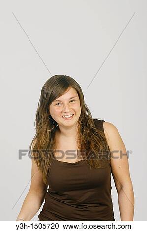 Stock Image - Studio shot of female teenager, smiling. Fotosearch