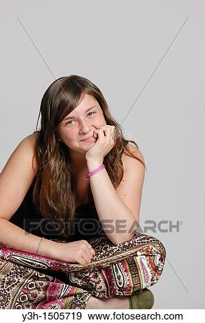Stock Photo - Studio shot of female teenager, smiling. Fotosearch