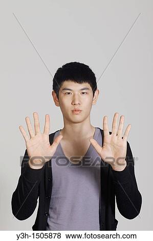 Studio shot of Korean man, showing hands View Large Photo Image Stock Photo - Studio shot of Korean man, showing hands. Fotosearch