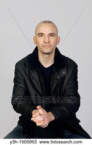 Stock Image - Studio shot of man with shaved head. Fotosearch