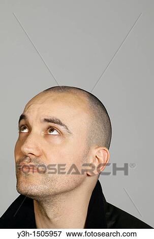 Studio shot of man with shaved head, looking upwards View Large Photo Image Stock Photo - Studio shot of man with shaved head, looking upwards. Fotosearch