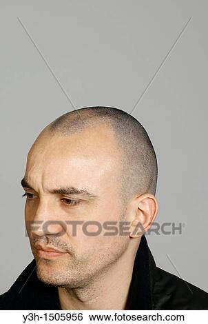 Studio shot of man with shaved head View Large Photo Image Stock Photograph - Studio shot of man with shaved head. Fotosearch