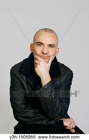 Stock Photography - Studio shot of man with shaved head. Fotosearch