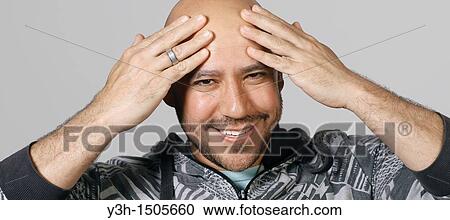 Stock Image - Studio shot of Mexican man, smiling. Fotosearch