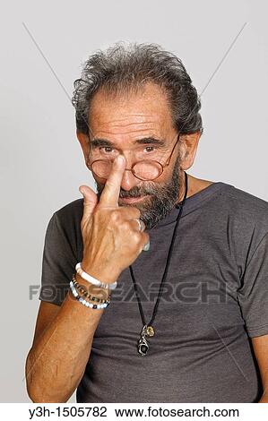 Stock Image - Studio shot of senior man, looking at camera. Fotosearch