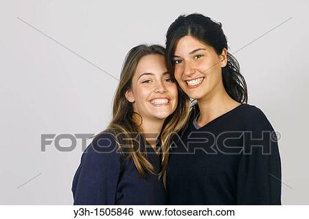 Studio shot of two young women, smiling View Large Photo Image Stock Photograph - Studio shot of two young women, smiling. Fotosearch