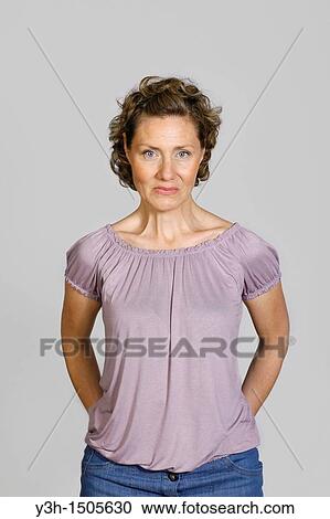 Stock Image - Studio shot of woman, looking at camera. Fotosearch