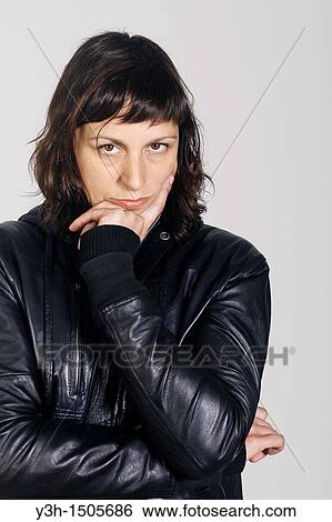 Stock Photograph - Studio shot of woman, looking at camera. Fotosearch