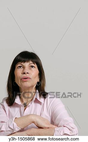 Stock Photo - Studio shot of woman, looking upwards. Fotosearch