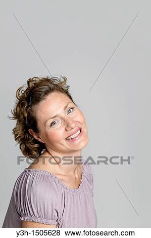 Stock Photo - Studio shot of woman, smiling. Fotosearch