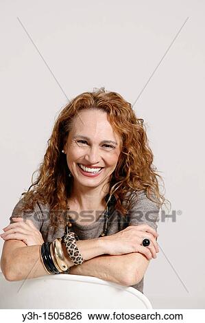 Stock Photograph - Studio shot of woman, smiling. Fotosearch