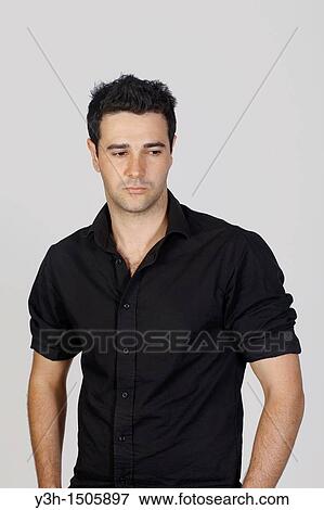 Stock Photo - Studio shot of young Brazilian man, sad. Fotosearch