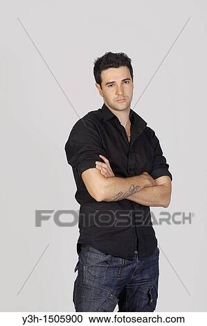 Stock Image - Studio shot of young Brazilian man, serious. Fotosearch