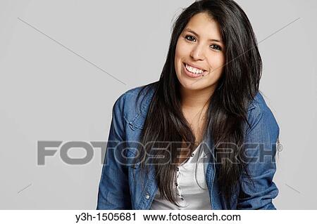 Stock Image - Studio shot of young Chilean woman, smiling. Fotosearch